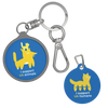 Two round metal keychains on a plain white background. One keychain has a blue tag with a yellow cat graphic and the text 'I support UA animals', while the other has a blue tag with a yellow cat graphic and the text 'I support UA humans'.
