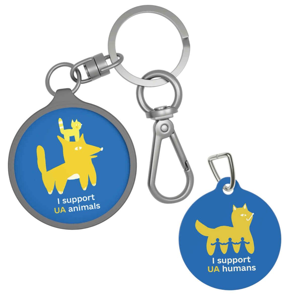 Two round metal keychains on a plain white background. One keychain has a blue tag with a yellow cat graphic and the text 'I support UA animals', while the other has a blue tag with a yellow cat graphic and the text 'I support UA humans'.